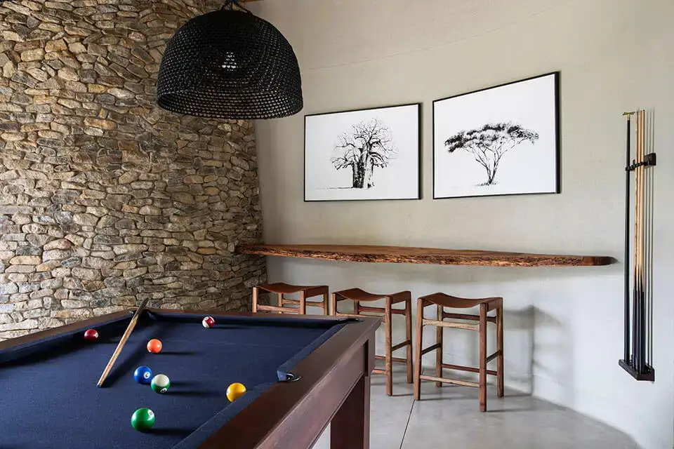 Pool table in stylish game room with art.