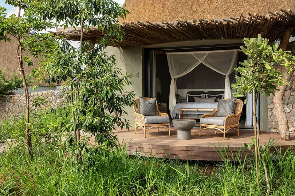 Cozy outdoor veranda with seating and lush greenery.