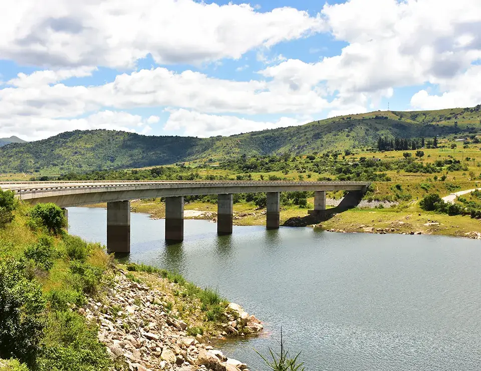 Concrete bridge over river with hilly landscape